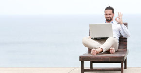 Homme avec un ordinateur en train de travailler au bord d'une piscine (Istock)